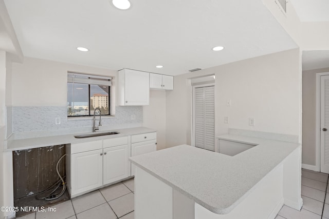 731 1st St S Unit 418, Jacksonville Beach, FL 32250 - kitchen featuring white cabinetry, light countertops, a sink, and tasteful backsplash