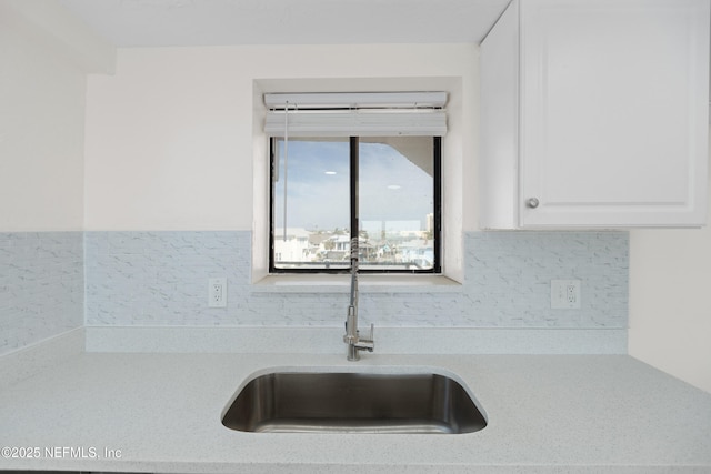 731 1st St S Unit 418, Jacksonville Beach, FL 32250 - details featuring white cabinetry, a sink, light countertops, and tasteful backsplash