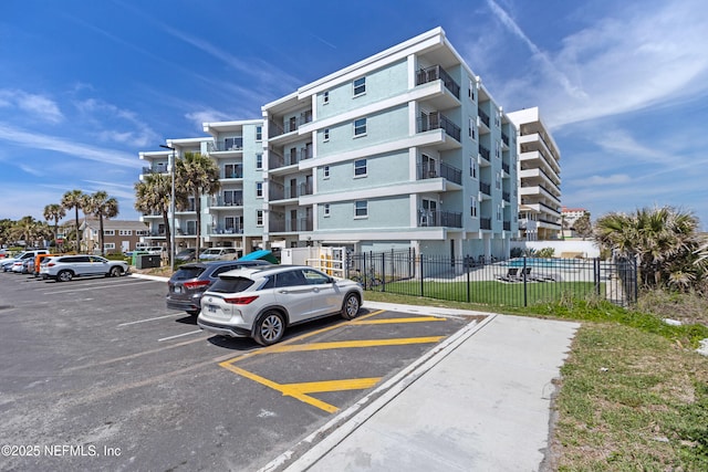 731 1st St S Unit 418, Jacksonville Beach, FL 32250 - view of building exterior with fence and uncovered parking