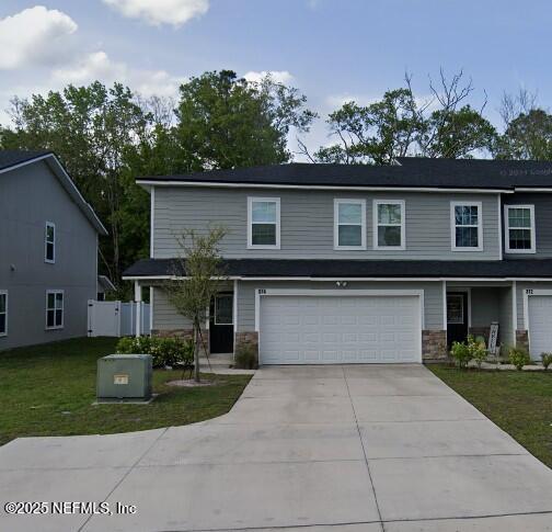 374 Old Jennings Rd, Middleburg, FL 32068 - traditional-style home featuring driveway, a front yard, an attached garage, and stone siding
