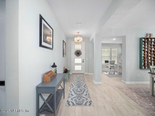 812 Windley Dr, Saint Augustine, FL 32092 - foyer featuring light wood-type flooring, baseboards, visible vents, and a notable chandelier