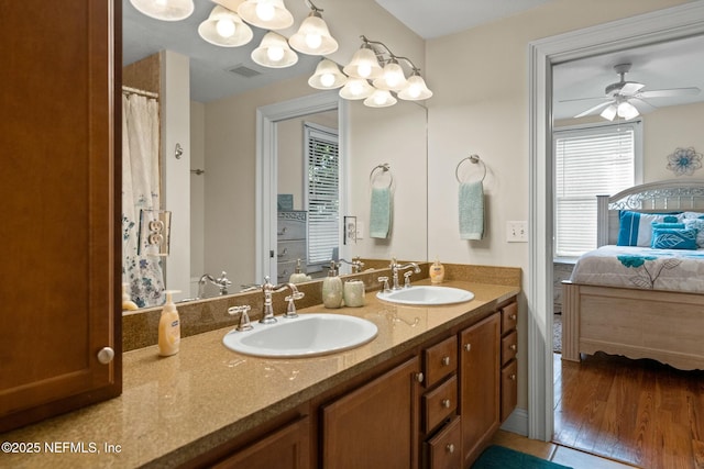 ensuite bathroom featuring double vanity, a sink, ensuite bathroom, and visible vents
