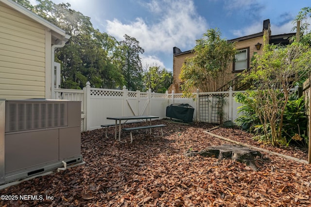 view of yard with a gate, central air condition unit, and a fenced backyard