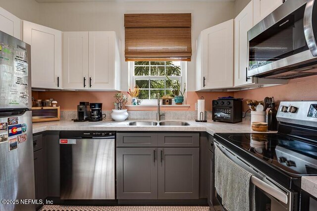 10961 Burnt Mill Rd Unit 321, Jacksonville, FL 32256 - kitchen with white cabinets, gray cabinets, a sink, light countertops, and stainless steel appliances