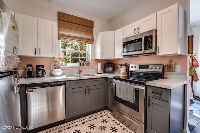 10961 Burnt Mill Rd Unit 321, Jacksonville, FL 32256 - kitchen with a sink, light countertops, appliances with stainless steel finishes, white cabinetry, and gray cabinetry