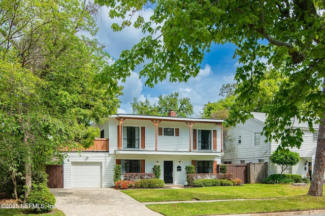 4245 Davinci Ave, Jacksonville, FL 32210 - view of front of house with decorative driveway, a front yard, fence, a chimney, and a garage