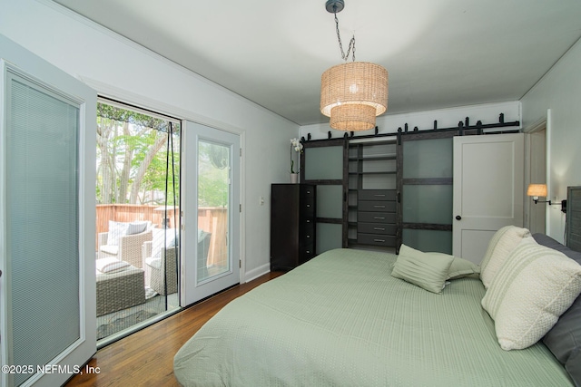 4245 Davinci Ave, Jacksonville, FL 32210 - bedroom featuring access to outside, wood finished floors, and a barn door