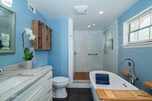 4245 Davinci Ave, Jacksonville, FL 32210 - bathroom with a stall shower, recessed lighting, toilet, visible vents, and wood finished floors
