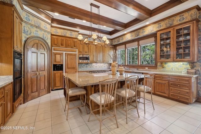 kitchen with decorative backsplash, light stone countertops, brown cabinets, built in appliances, and light tile patterned flooring