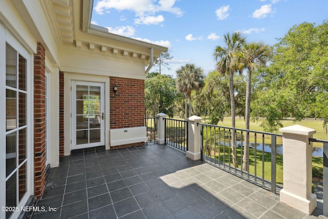 view of patio / terrace with a water view and a balcony