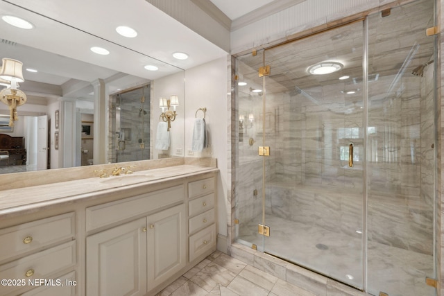 bathroom featuring vanity, ornamental molding, marble finish floor, recessed lighting, and a shower stall