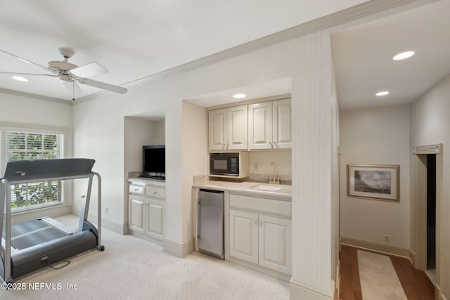 interior space with crown molding, a sink, baseboards, and recessed lighting