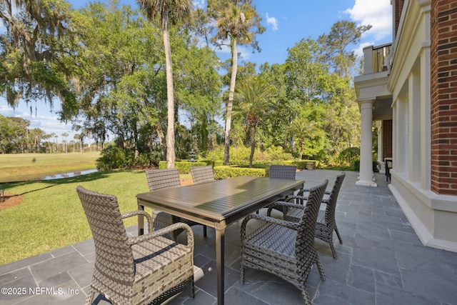 view of patio featuring a water view and outdoor dining area
