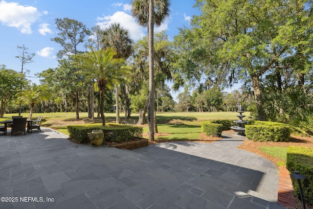 surrounding community with a lawn, outdoor dining area, and a patio area