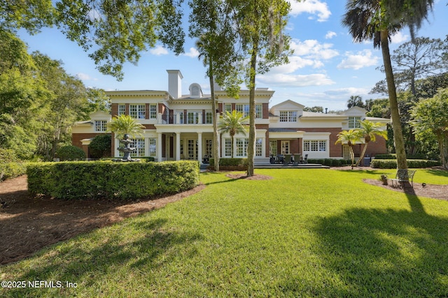 back of property featuring a lawn, french doors, and a chimney