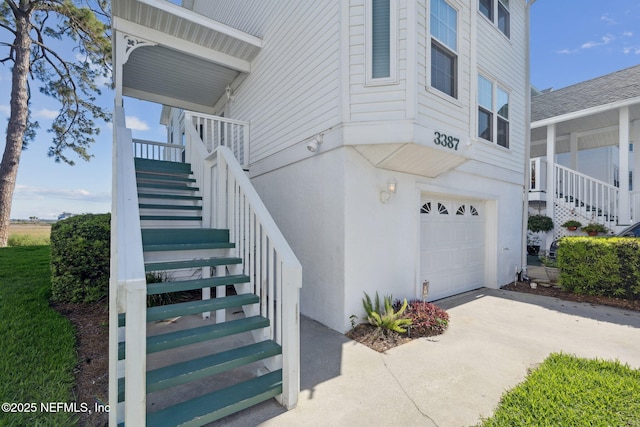 3387 Lighthouse Point Ln, Jacksonville, FL 32250 - view of exterior entry featuring concrete driveway, stucco siding, and an attached garage