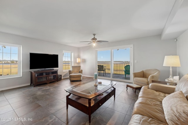 3387 Lighthouse Point Ln, Jacksonville, FL 32250 - living room with tile patterned flooring, baseboards, a ceiling fan, and a healthy amount of sunlight