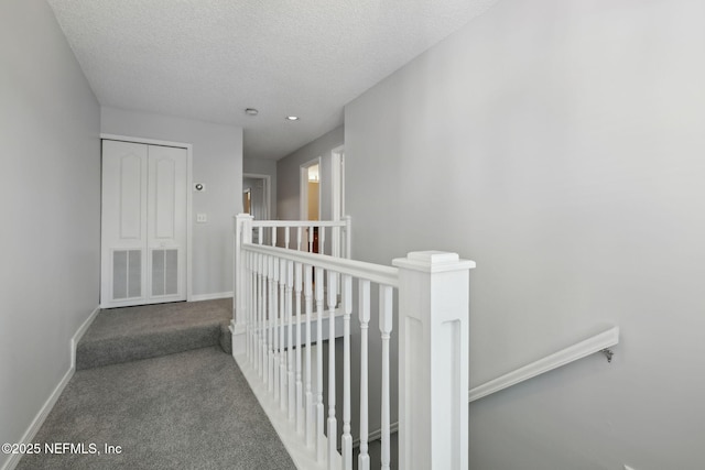 3387 Lighthouse Point Ln, Jacksonville, FL 32250 - hall with a textured ceiling, baseboards, carpet, and an upstairs landing
