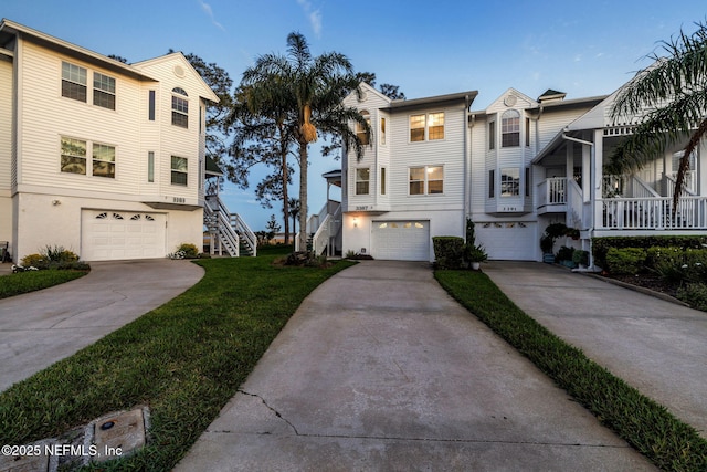 3387 Lighthouse Point Ln, Jacksonville, FL 32250 - view of front of property featuring a garage, stairs, stucco siding, and concrete driveway