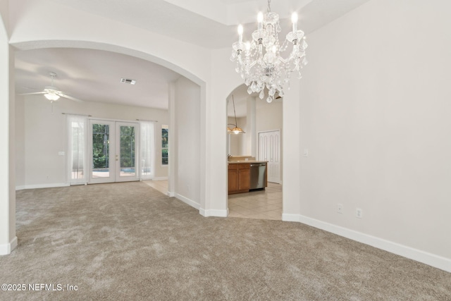 86183 Hampton Bays Dr, Fernandina Beach, FL 32034 - empty room featuring light carpet, arched walkways, ceiling fan, french doors, and a chandelier