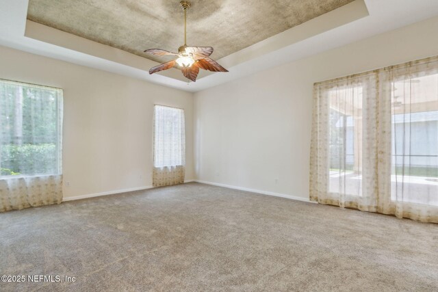 86183 Hampton Bays Dr, Fernandina Beach, FL 32034 - carpeted empty room with a tray ceiling and a ceiling fan