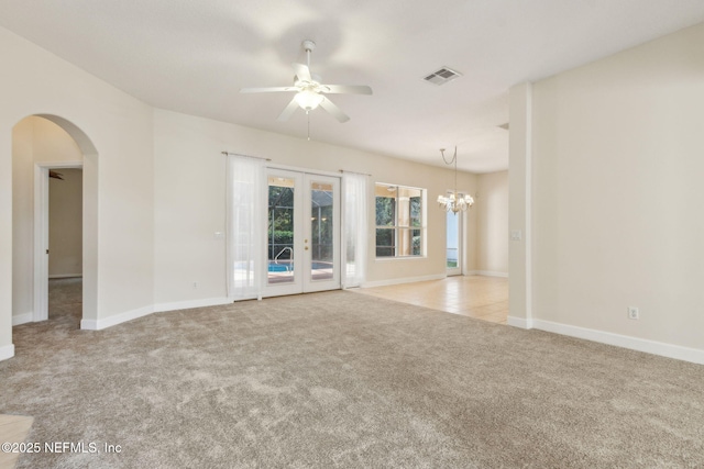 86183 Hampton Bays Dr, Fernandina Beach, FL 32034 - spare room featuring carpet, ceiling fan, french doors, arched walkways, and a chandelier