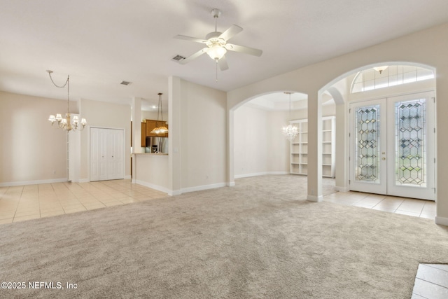 86183 Hampton Bays Dr, Fernandina Beach, FL 32034 - unfurnished living room with a chandelier, light carpet, arched walkways, and light tile patterned floors