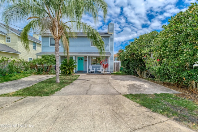 539 Upper 8th Ave S, Jacksonville Beach, FL 32250 - view of front facade with a chimney, covered porch, fence, and concrete driveway