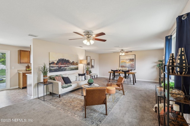 carpeted living area featuring baseboards, ceiling fan, and visible vents