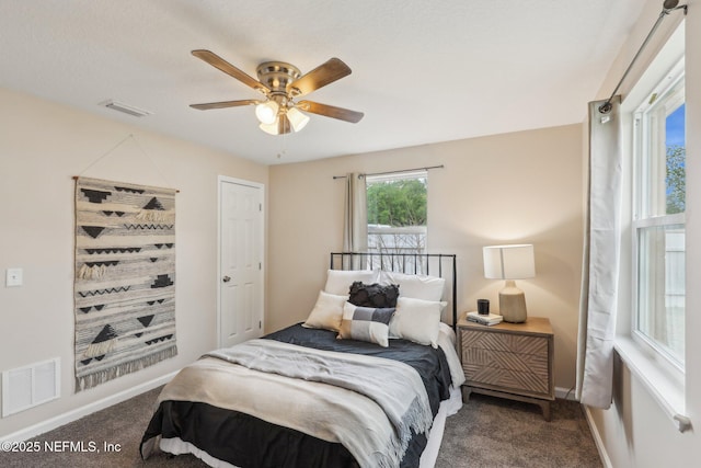 carpeted bedroom featuring baseboards, ceiling fan, and visible vents