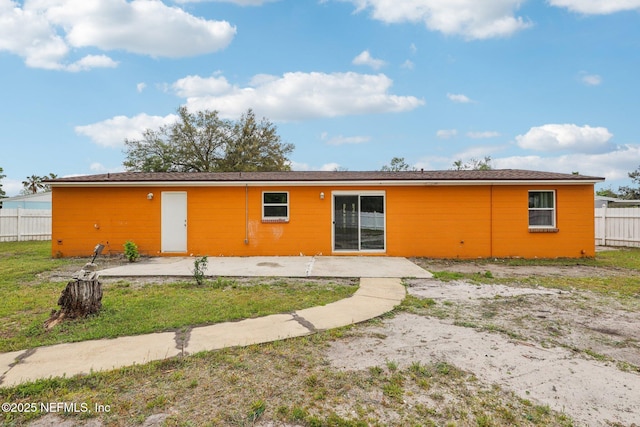 back of property featuring fence and a patio