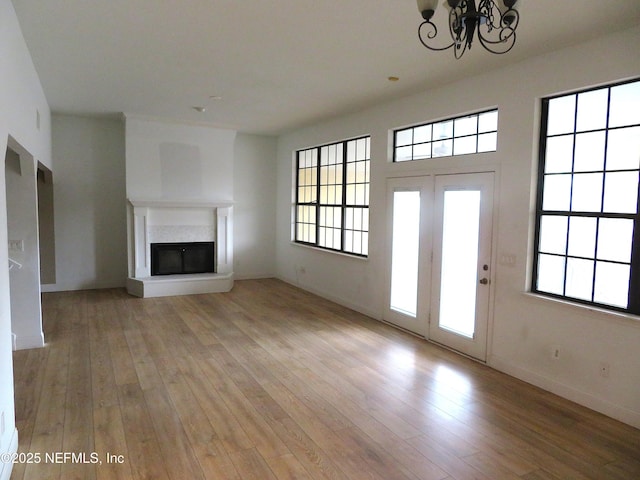 29 Fox Valley Dr, Orange Park, FL 32073 - unfurnished living room with a wealth of natural light, a glass covered fireplace, an inviting chandelier, and light wood finished floors