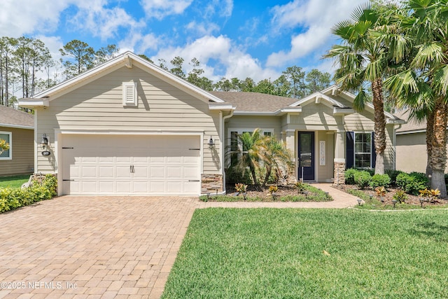 699 Aspen Leaf Dr, Jacksonville, FL 32081 - view of front of house with stone siding, decorative driveway, an attached garage, a front yard, and a shingled roof