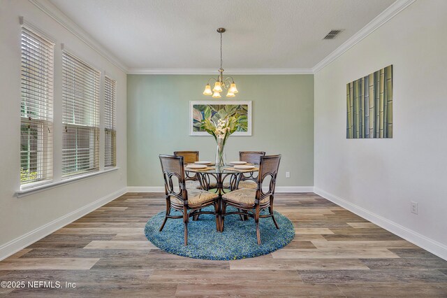 699 Aspen Leaf Dr, Jacksonville, FL 32081 - dining room with visible vents, a chandelier, baseboards, ornamental molding, and wood finished floors