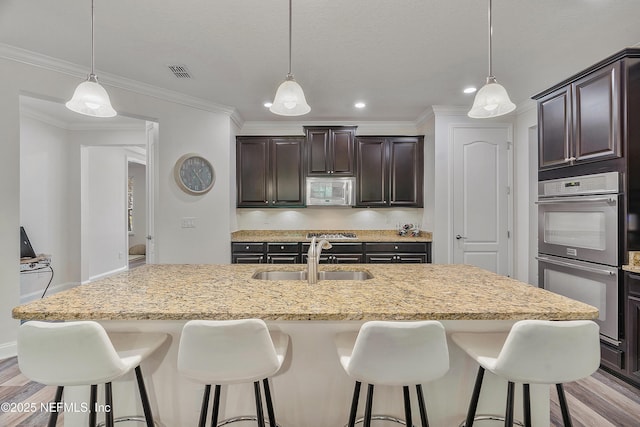699 Aspen Leaf Dr, Jacksonville, FL 32081 - kitchen with visible vents, stainless steel double oven, dark brown cabinets, a sink, and a kitchen breakfast bar