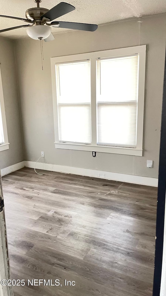 719 Broxton St, Jacksonville, FL 32208 - empty room featuring a textured ceiling, baseboards, wood finished floors, and a ceiling fan