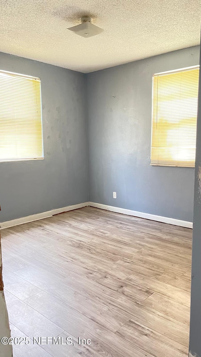719 Broxton St, Jacksonville, FL 32208 - empty room with plenty of natural light, baseboards, wood finished floors, and a textured ceiling