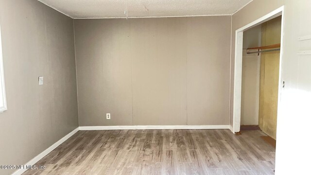 719 Broxton St, Jacksonville, FL 32208 - unfurnished bedroom featuring baseboards, a textured ceiling, wood finished floors, and a closet