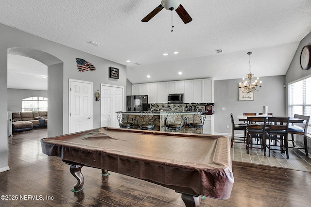 playroom with arched walkways, a healthy amount of sunlight, ceiling fan with notable chandelier, billiards, and vaulted ceiling