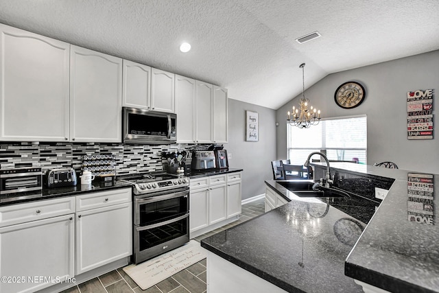 kitchen featuring a sink, white cabinetry, tasteful backsplash, stainless steel appliances, and visible vents