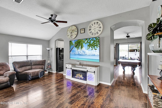living room featuring wood finished floors, arched walkways, lofted ceiling, and ceiling fan