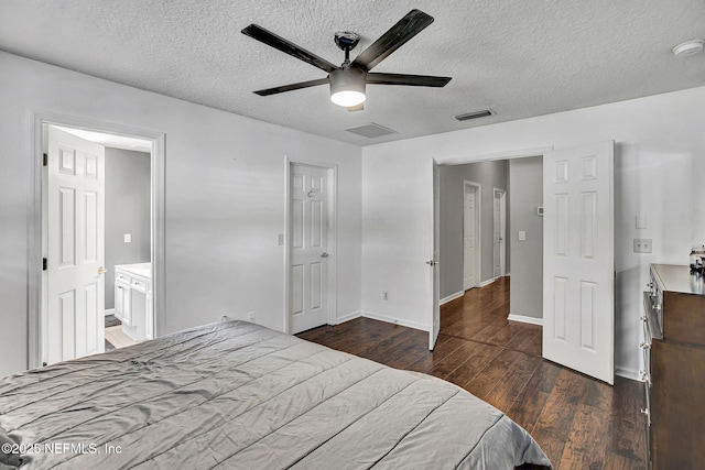 bedroom featuring baseboards, a textured ceiling, visible vents, and wood finished floors