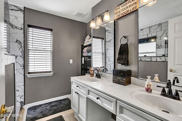 bathroom with double vanity, a sink, and a healthy amount of sunlight