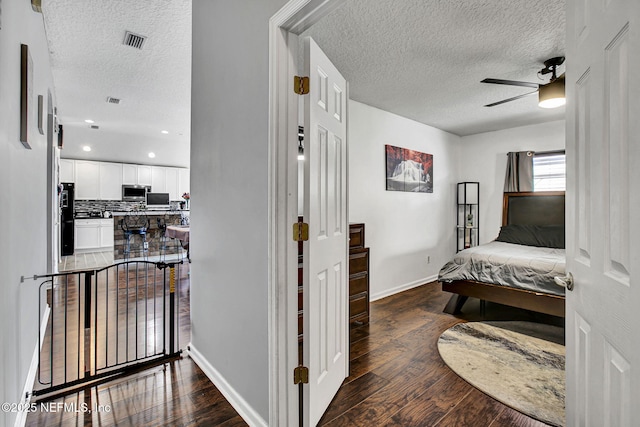 interior space with baseboards, hardwood / wood-style flooring, and a textured ceiling