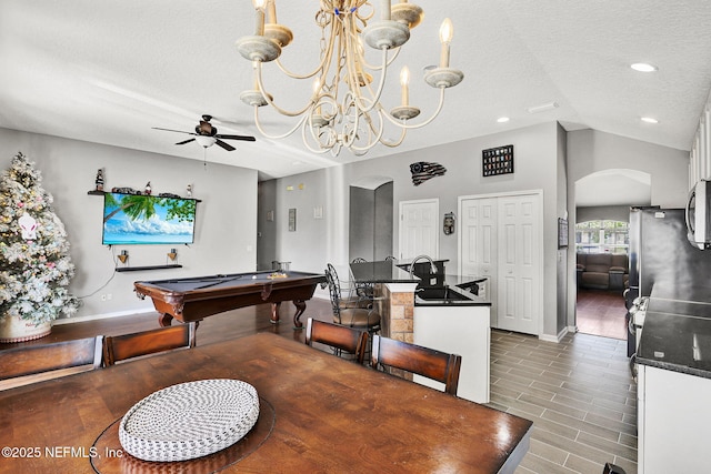 dining area featuring arched walkways, a textured ceiling, lofted ceiling, and ceiling fan