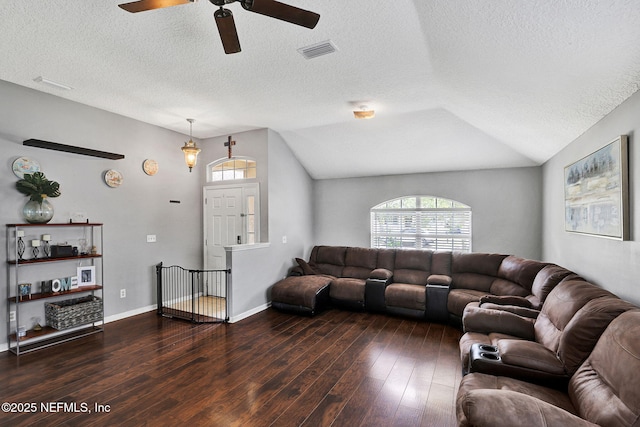 living room with a ceiling fan, dark wood-style flooring, lofted ceiling, and visible vents