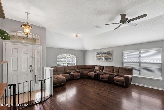 living area with hardwood / wood-style floors, lofted ceiling, visible vents, and a ceiling fan
