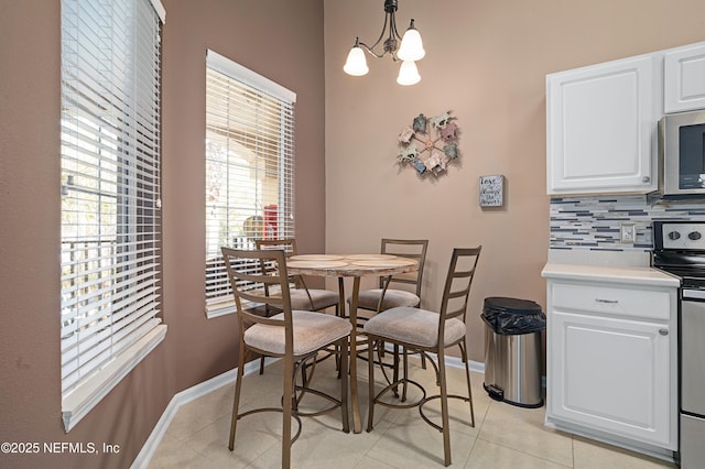 dining room featuring baseboards, an inviting chandelier, and light tile patterned floors