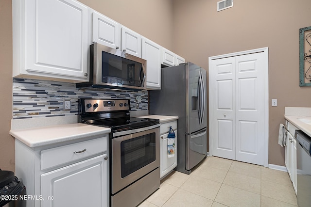kitchen featuring white cabinets, tasteful backsplash, appliances with stainless steel finishes, and visible vents