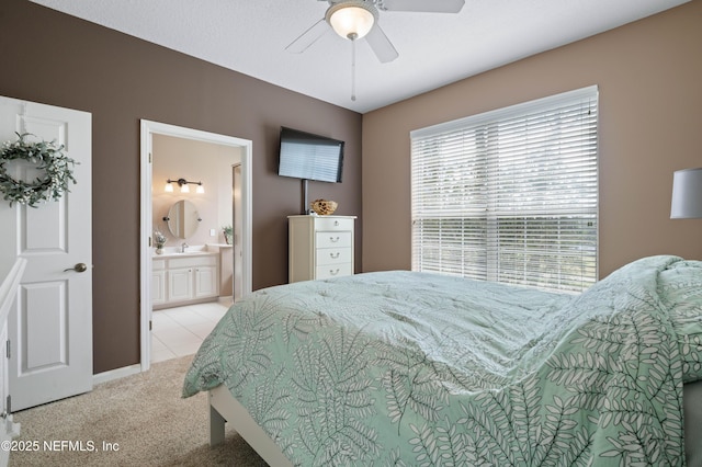 bedroom featuring carpet floors, ensuite bathroom, and a ceiling fan